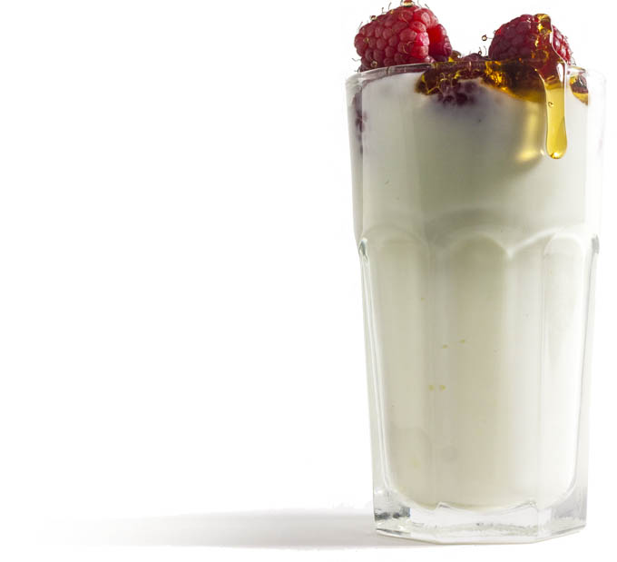 Raspberries and honey in a glass of yogurt